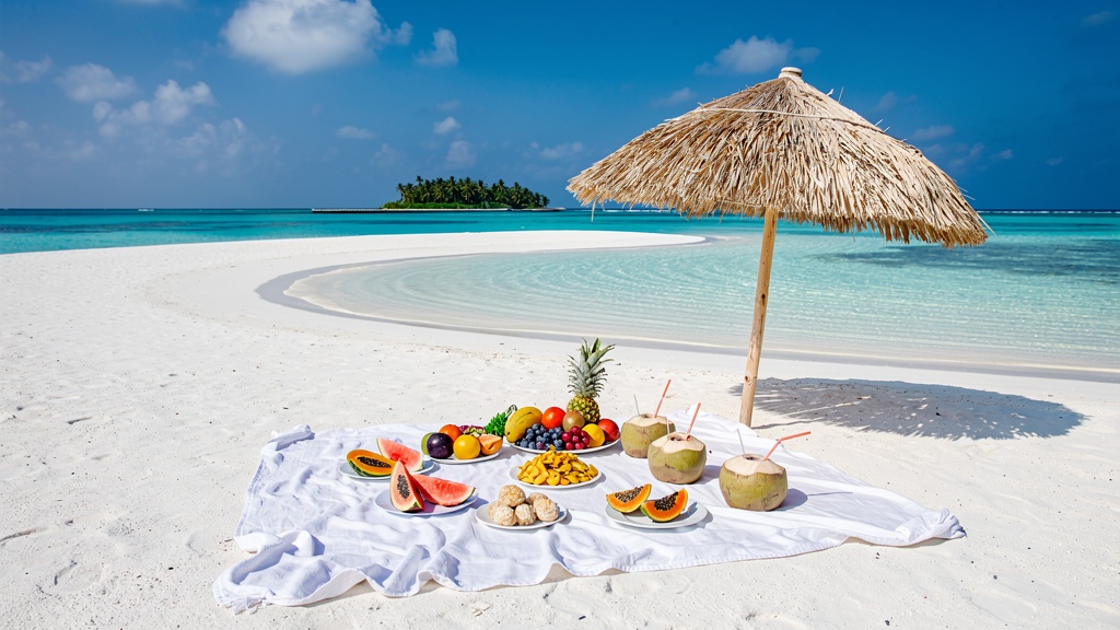 Sandbank picnic with fruit and coconut water